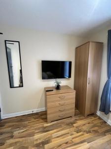 a living room with a dresser and a flat screen tv at Shared Room in Ashton under Lyne