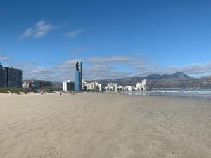 a sandy beach with a city in the background at Strand Stay Cottage in Strand