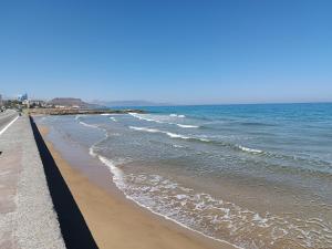 a beach with waves coming in from the ocean at Niros Beachfront Aparthotel in Kokkíni Khánion +37 photos