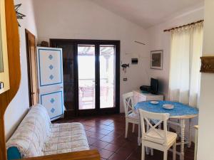 een woonkamer met een bank en een tafel bij Villetta Bouganville vista mare in Porto Ottiolu