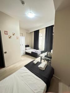 a bedroom with two beds and a desk in it at GLR OTEL in Balıkesir