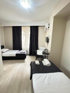 a hotel room with two beds and a desk at GLR OTEL in Balıkesir