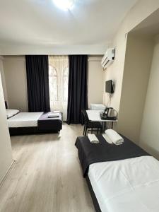 a hotel room with two beds and a desk at GLR OTEL in Balıkesir