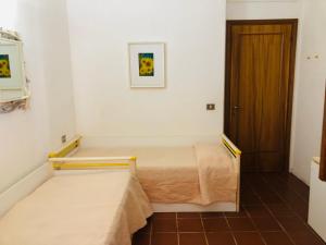 een kleine kamer met een bed en een houten deur bij Villetta Bouganville vista mare in Porto Ottiolu