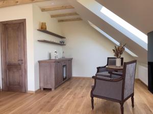 a living room with a chair and a wooden floor at Karlamuiza Country Hotel in Kārļi
