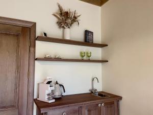 a kitchen with a sink and two wine glasses at Karlamuiza Country Hotel in Kārļi