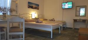 a room with two beds and a tv on the wall at Margaritari Sifnos in Platis Gialos
