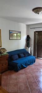 a bed in a room with a blue cover on the floor at Villetta Le Rocche - Rocca di Cambio in Rocca di Cambio