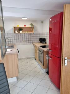 a kitchen with a red refrigerator in a room at Ferienwohnung Heppenheim an der Bergstraße WHG 1 in Heppenheim an der Bergstrasse +6 photos