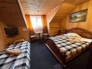 a bedroom with two beds in a wooden cabin at Trembita in Mizhhirʼʼya