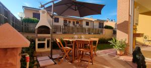 a table and chairs under an umbrella on a patio at Casa Totò in Venturina Terme