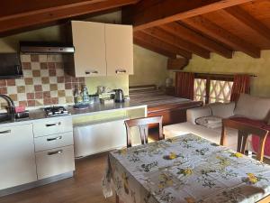 a kitchen and living room with a table and a stove at Country House La Montagnola in Valdobbiadene