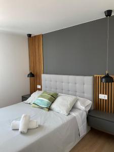 a bedroom with a large white bed with two pillows at Apartamentos A Xunqueira in Redondela
