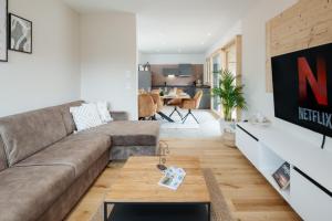 sala de estar con sofá y mesa en FENJOY: Großes Ferienapartment im Neubau / Balkon / BBQ, en Bernau am Chiemsee