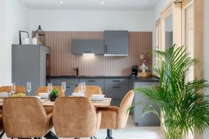 comedor con mesa y sillas en la cocina en FENJOY: Großes Ferienapartment im Neubau / Balkon / BBQ, en Bernau am Chiemsee