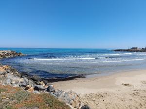 una playa con rocas y el océano en un día soleado en Niros Beachfront Aparthotel, en Kokkíni Khánion