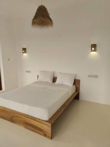 a bed in a white room with two lights at Luxury White Villa in Nungwi