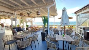 メガロホリにあるHotel Beach Amaryllisのテーブルと椅子、傘が備わるレストラン