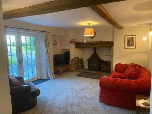 een woonkamer met een rode bank en een open haard bij The Cottage in Exeter