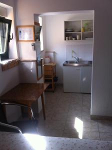 a small kitchen with a table and a refrigerator at DeltaS Appartmani in Banjol