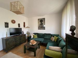 ein Wohnzimmer mit einem grünen Sofa und einem TV in der Unterkunft Villa Nikola in Kotor
