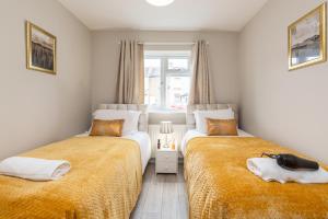 2 camas en una habitación pequeña con ventana en Dartford, Kent - Modern 2Bd 2Bath En-Suite Bungalow M25 Bluewater en Dartford