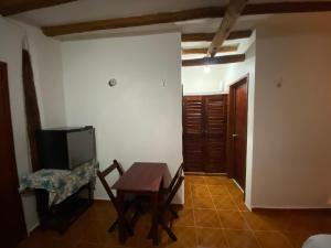 a room with a table and a chair and a television at Casa Victor Avila in Holbox Island