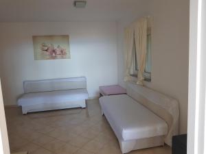 a white room with two benches and a window at Apartment Oasis - Novalja in Novalja