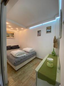 Villa Nikola في كوتور: غرفة نوم صغيرة مع سرير وطاولة