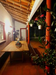 uma sala de jantar com uma mesa de madeira e algumas plantas em Quinta da Maínha - Charming Houses em Braga