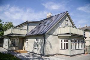 a house with a gambrel roof with a porch at Haapsalu Guesthouse in Haapsalu
