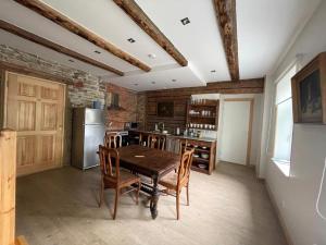 a kitchen with a wooden table and a refrigerator at Haapsalu Guesthouse in Haapsalu