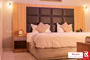 a bedroom with a large bed with a large headboard at Best Trip Serviced Apartments in Jeddah