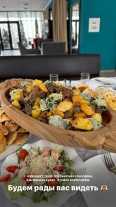 een houten bord eten op een tafel bij AlmaPort in Talghar