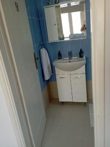 Baño pequeño con lavabo y espejo en Captain's Nest, en Ándros