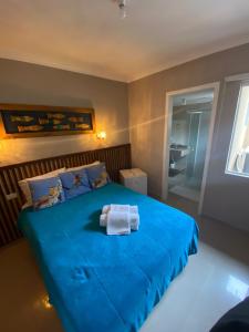 MatinhosにあるPousada Praia Bravaのベッドルーム1室(タオル付きの青いベッド1台付)