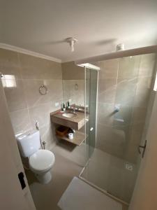 ein Bad mit einem WC, einer Dusche und einem Waschbecken in der Unterkunft Pousada Praia Brava in Matinhos