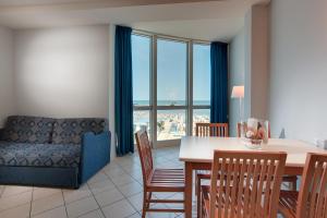 - un salon avec une table, des chaises et un canapé dans l'établissement Hotel Valverde & Residenza, à Cesenatico