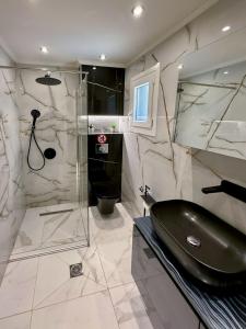 a bathroom with a glass shower and a black bidet at Villa Eden in Iraklitsa