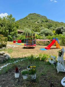 a playground with a slide and a swing set at Villa Eden in Iraklitsa