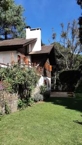 a house with a lawn in front of it at Refúgio do Selado in Monte Verde