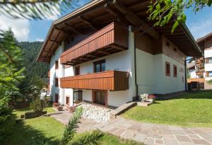 una casa con un balcón en el lateral. en Apartments Lores, en Selva di Val Gardena