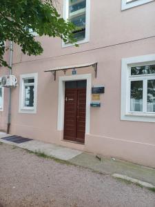 a pink building with a brown door on it at Apartment K&M in Senj