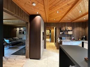 a kitchen with wooden ceilings and a living room at Trysil Moderna Lodge in Trysil