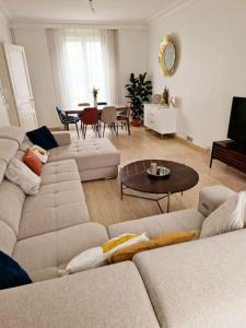 a living room with two couches and a table at Grande maison en Bords de Marne - 25 min de Paris in Créteil