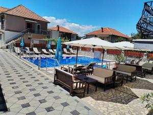 een zwembad met stoelen en parasols naast een resort bij Villa Mimi in Peštani