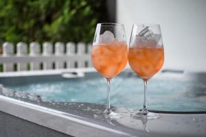 two wine glasses sitting on a ledge next to a swimming pool at Kuća za odmor 204 jezero Šoderica in Legrad