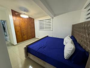 a bedroom with a blue bed and a wooden cabinet at Casa en Santiago por el Homs in Santiago de los Caballeros