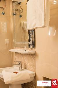 a bathroom with a sink and a toilet and a mirror at Best Trip Paris Serviced Apartments in Jeddah +49 photos
