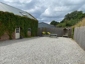 a patio with a bench next to a building at The Brick Barn, Drewsteignton in Exeter